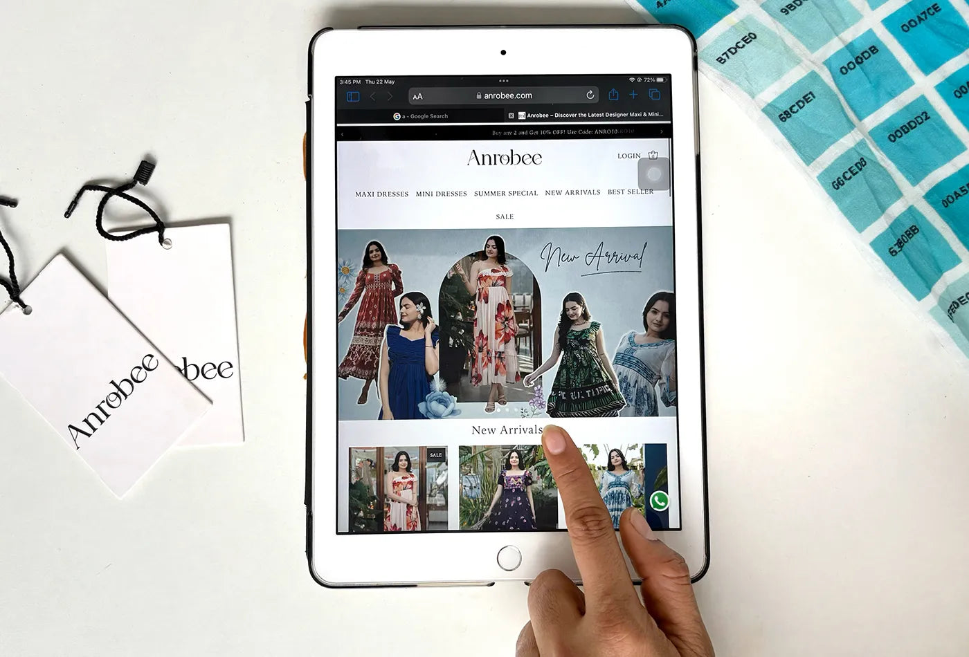 Anrobee online store launch featuring the new arrivals collection displayed on a tablet with brand tags and packaging beside it.