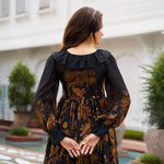 Back view of a black floral print midi dress with soft gathers and ruffles
