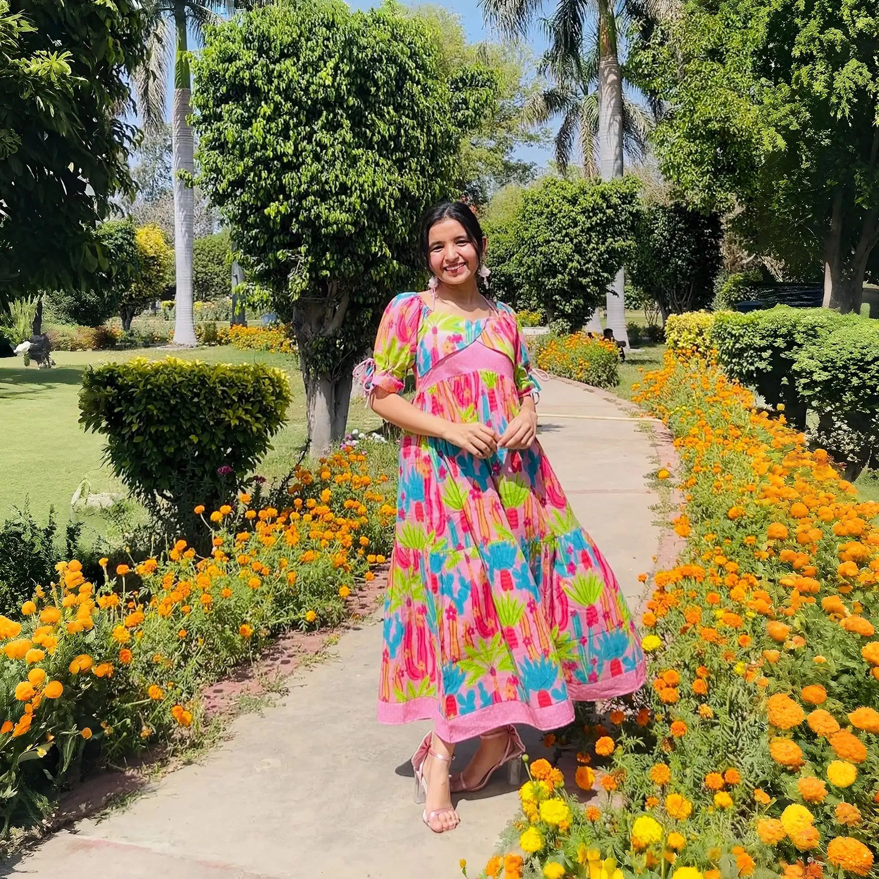 Smiling influencer in designer cotton dress for women with vivid cactus print.