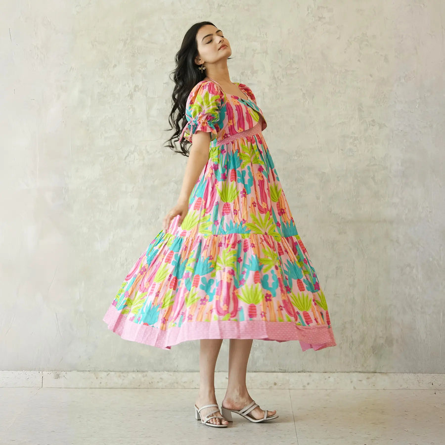 Designer dress for women twirling gracefully with pink cactus motifs.