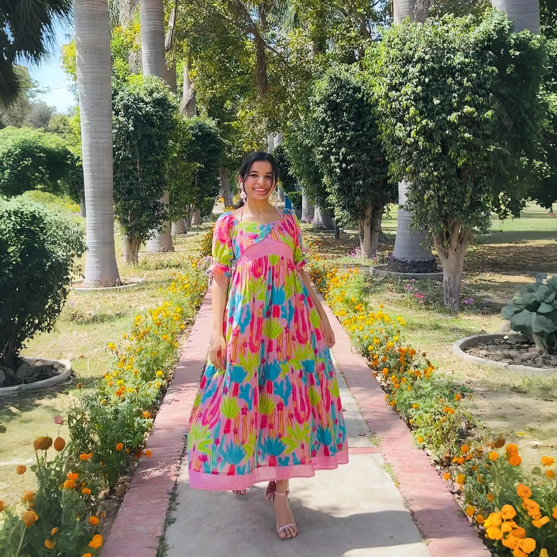 Influencer walking outdoors in long dress for women with cactus print.