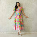 Relaxed standing pose in a long blush cactus print dress for women.