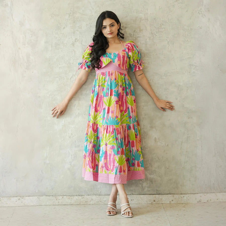 Relaxed standing pose in a long blush cactus print dress for women.