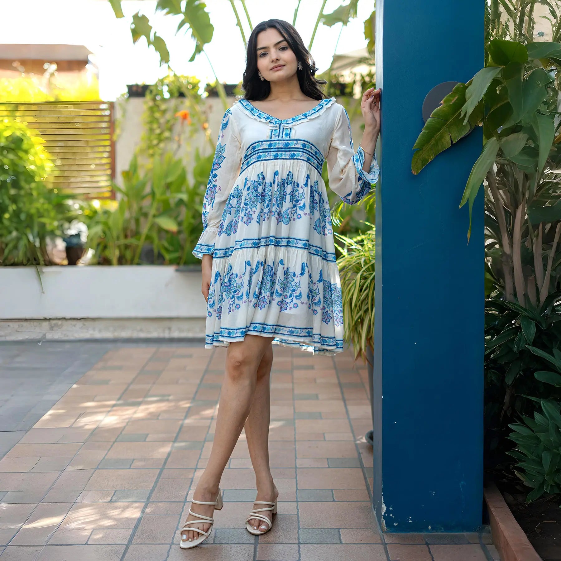Front view of a white short dress for women with puff sleeves and tiered knee length design