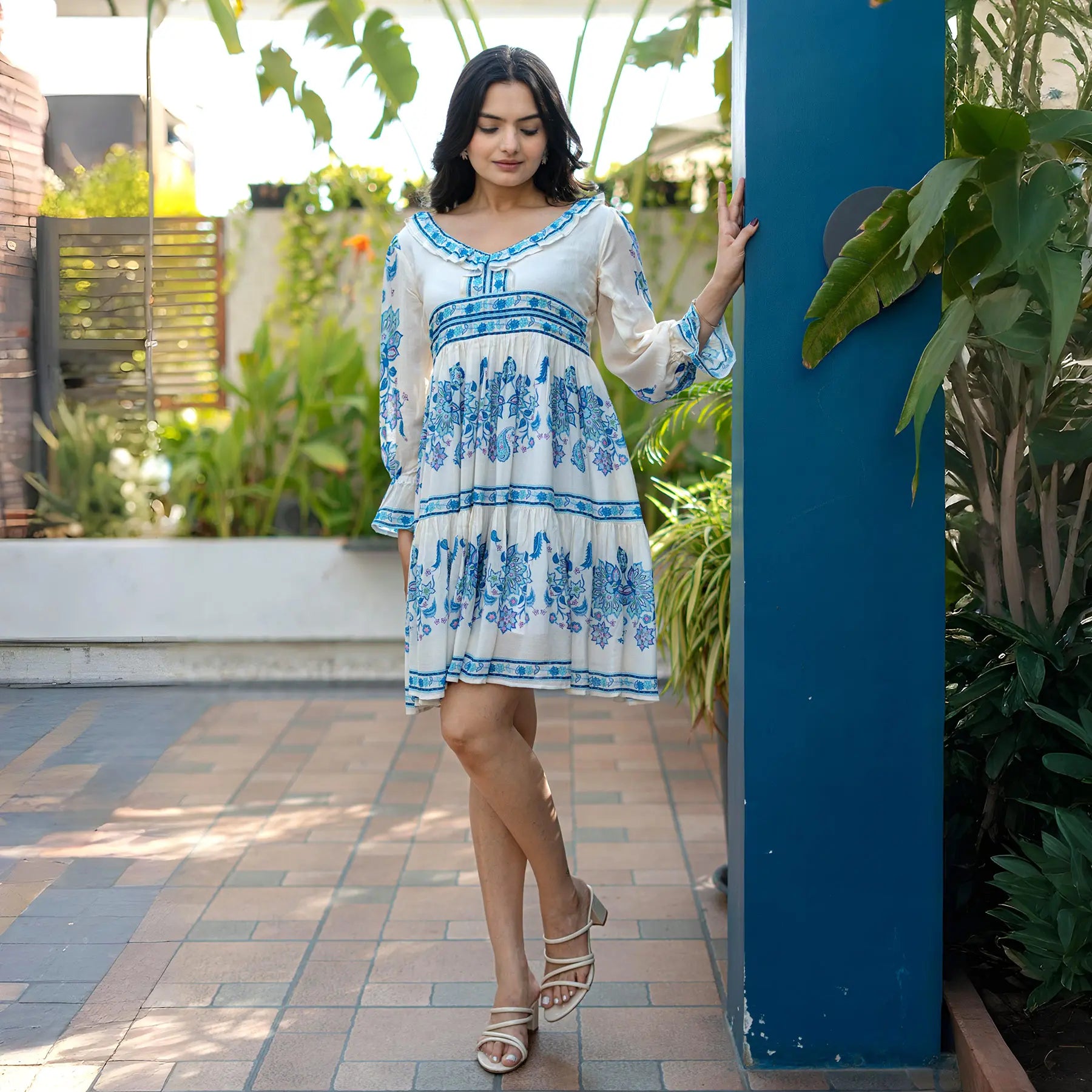 Relaxed pose showing a breezy knee length one piece dress with boho print and airy silhouette.