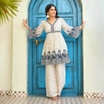 Playful extended arm pose highlighting the printed co ord set for women with navy floral borders.