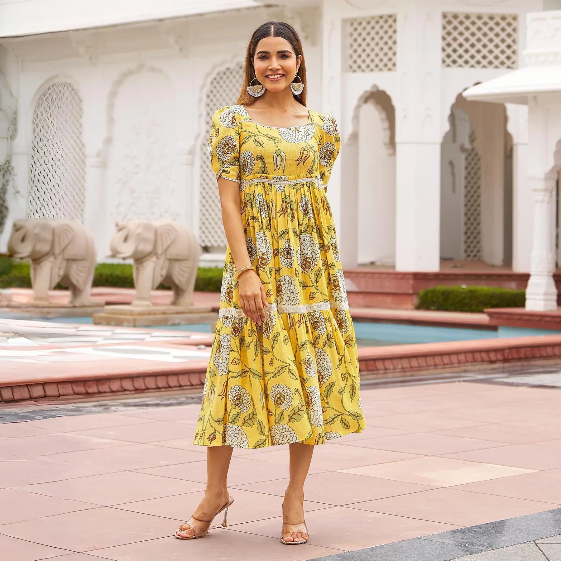 Woman wearing a yellow floral midi dress with puff sleeves — elegant outfit for festive gatherings and haldi functions.