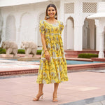 Marigold Aura – front pose of yellow floral midi dresses for women with puffed sleeves, ideal for summer outings.