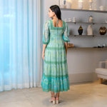 Back view of aqua one piece long maxi dress with tie-up detail and puff sleeves, adding elegance.
