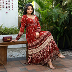 Model seated in a maroon full sleeve maxi dress with boho prints — elegant choice for Diwali parties and family gatherings.