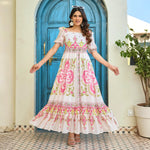 Women wearing maxi dress with colorful motif print twirling beautifully, highlighting its flared hem and lightweight fabric.