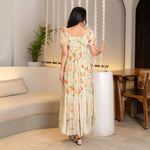 Back view highlighting the flow of the long floral maxi one piece, styled for travel and evening outings.