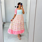 Real mirror selfie showing an A-line floral maxi styled for summer vacations.