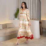 Walking side profile in a breezy floral maxi dress, designed for outdoor events and vacation outings.