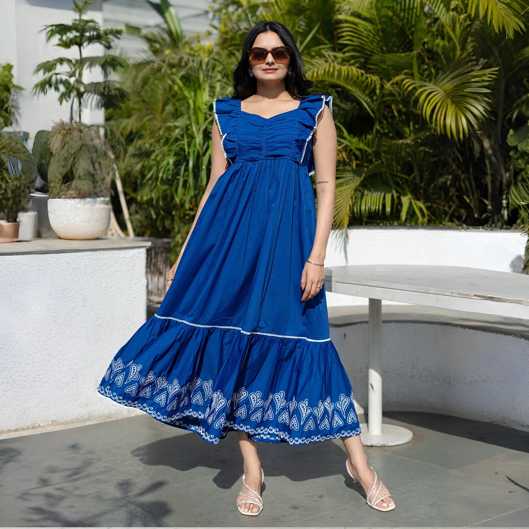 Model in a sleeveless blue maxi dress for women, standing in a front pose with airy silhouette.
