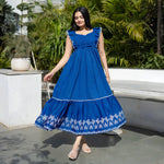 Model twirling in a flowy maxi dress with embroidered border and breezy movement.