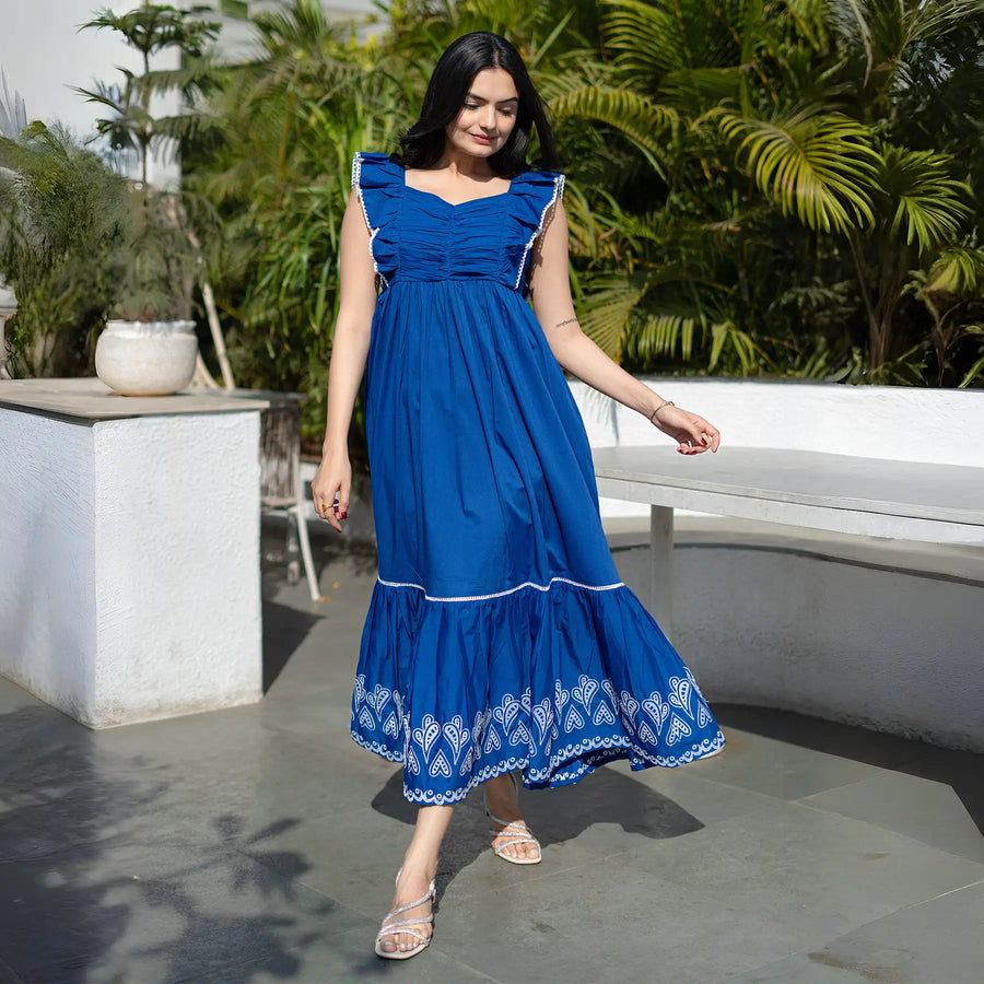 Walking pose in an A-line maxi dress, styled casually for vacation and resort wear.