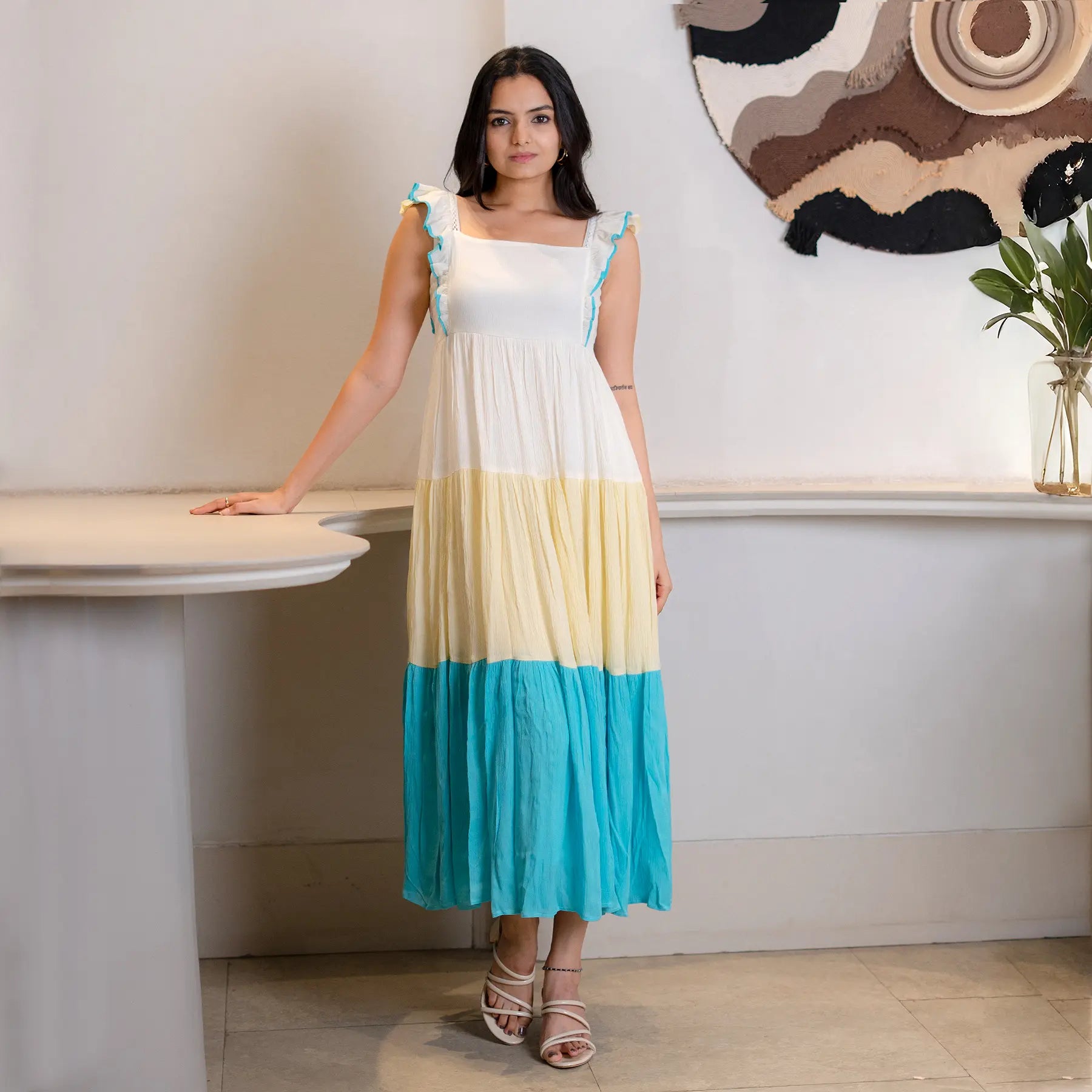 Model in a sleeveless A-line maxi dress for women, front pose with flowy hemline.