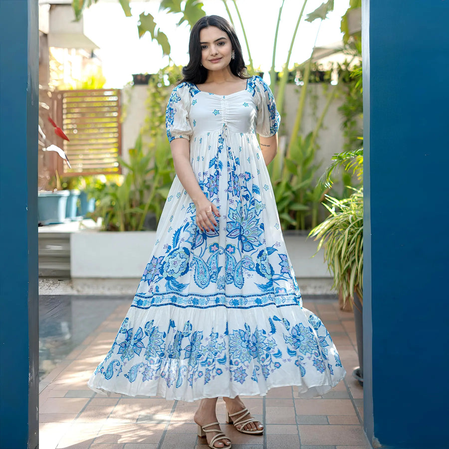 Model smiling in a flowy A-line maxi dress with bold floral prints, styled for casual getaways.