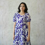 Close-up view of one piece dress highlighting puff sleeves and bold abstract print.