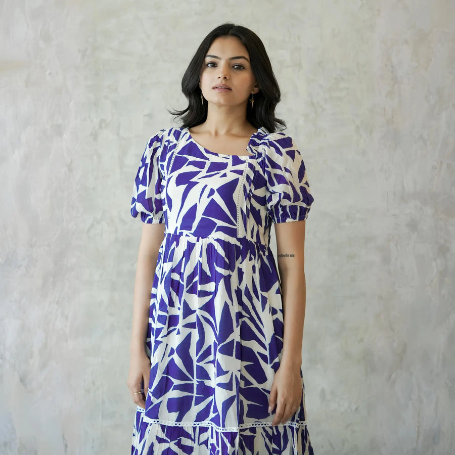 Close-up view of one piece dress highlighting puff sleeves and bold abstract print.