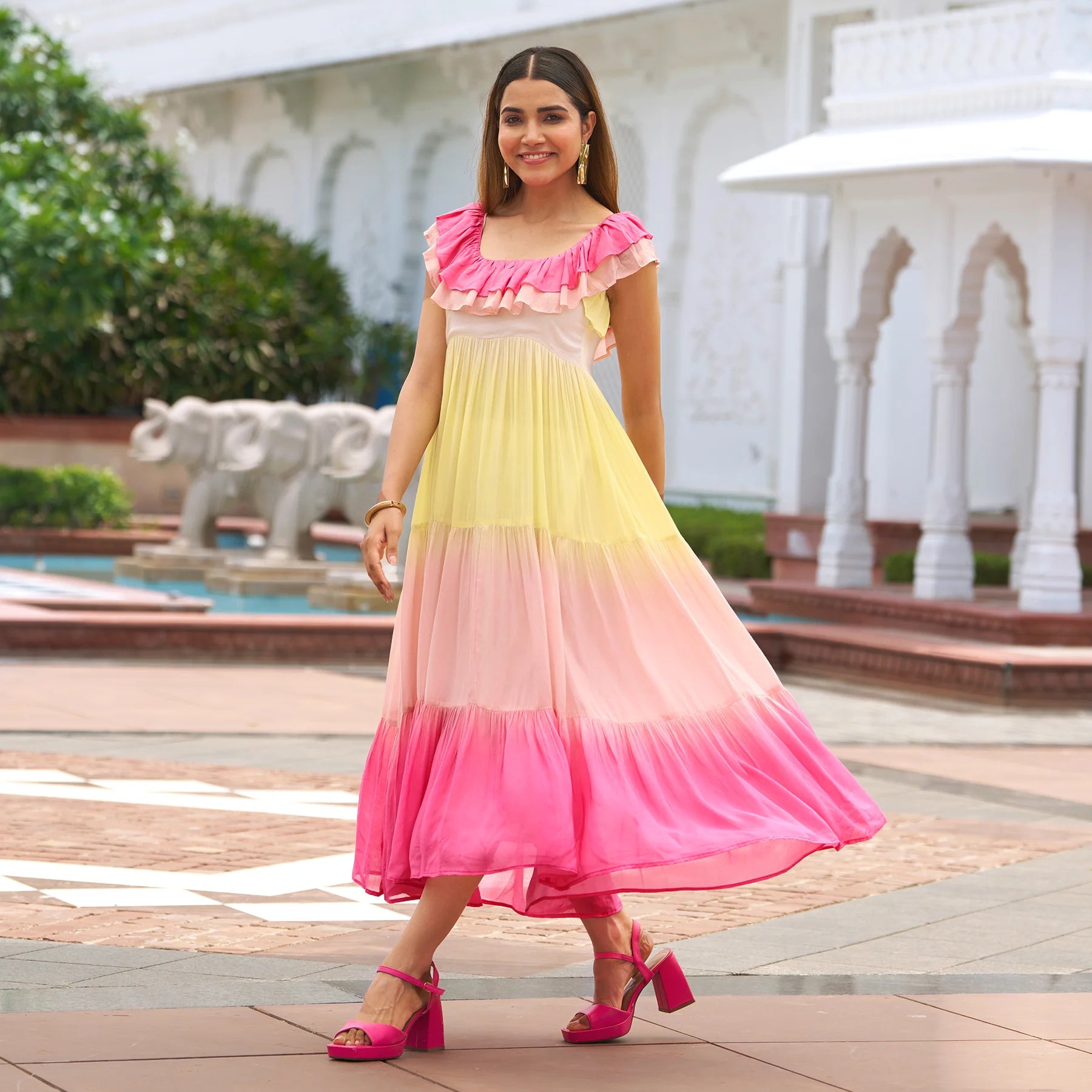 Model walking in a colorful one piece midi dress with pink and yellow tones — chic beach outfit.