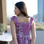Back view of the dress featuring ruffled straps and a flowing floral A-line silhouette.