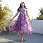Woman twirling in a lilac floral midi dress with ruffled straps, showing its flowy A-line silhouette.