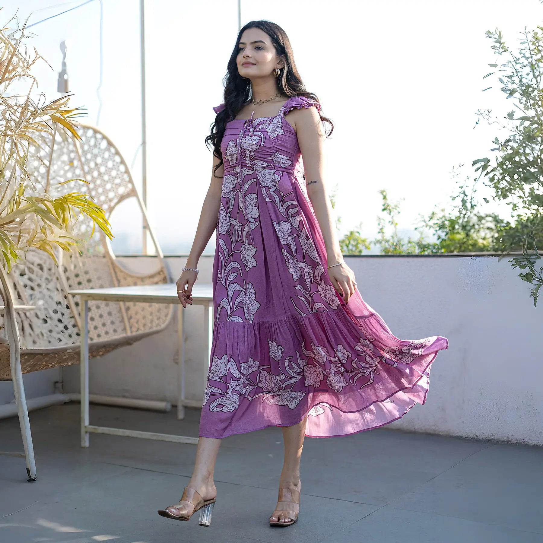 Sleeveless floral print dress in soft lilac, moving gracefully as she walks.