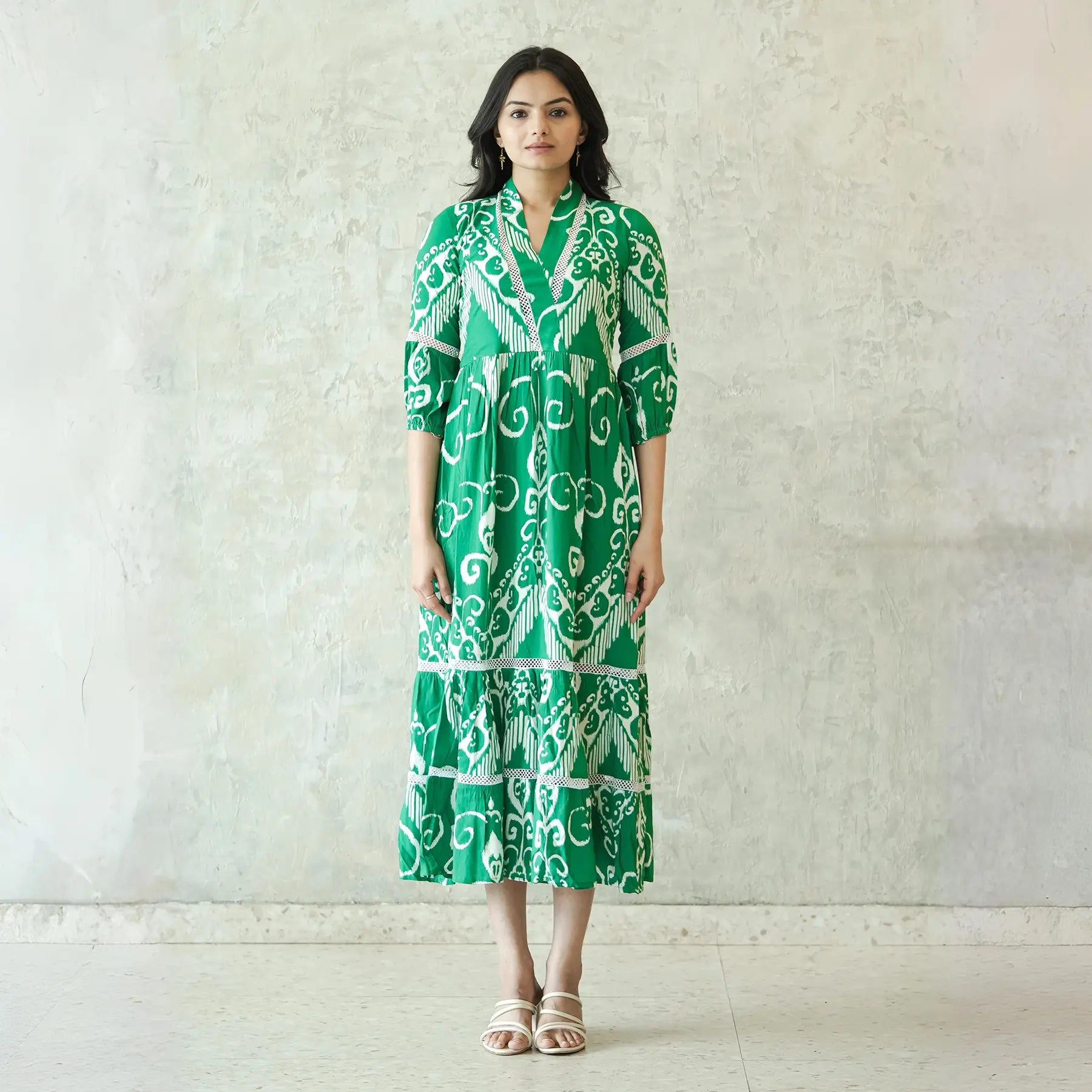 Woman in a green midi dress for women, front view highlighting tiered silhouette and collared neckline.