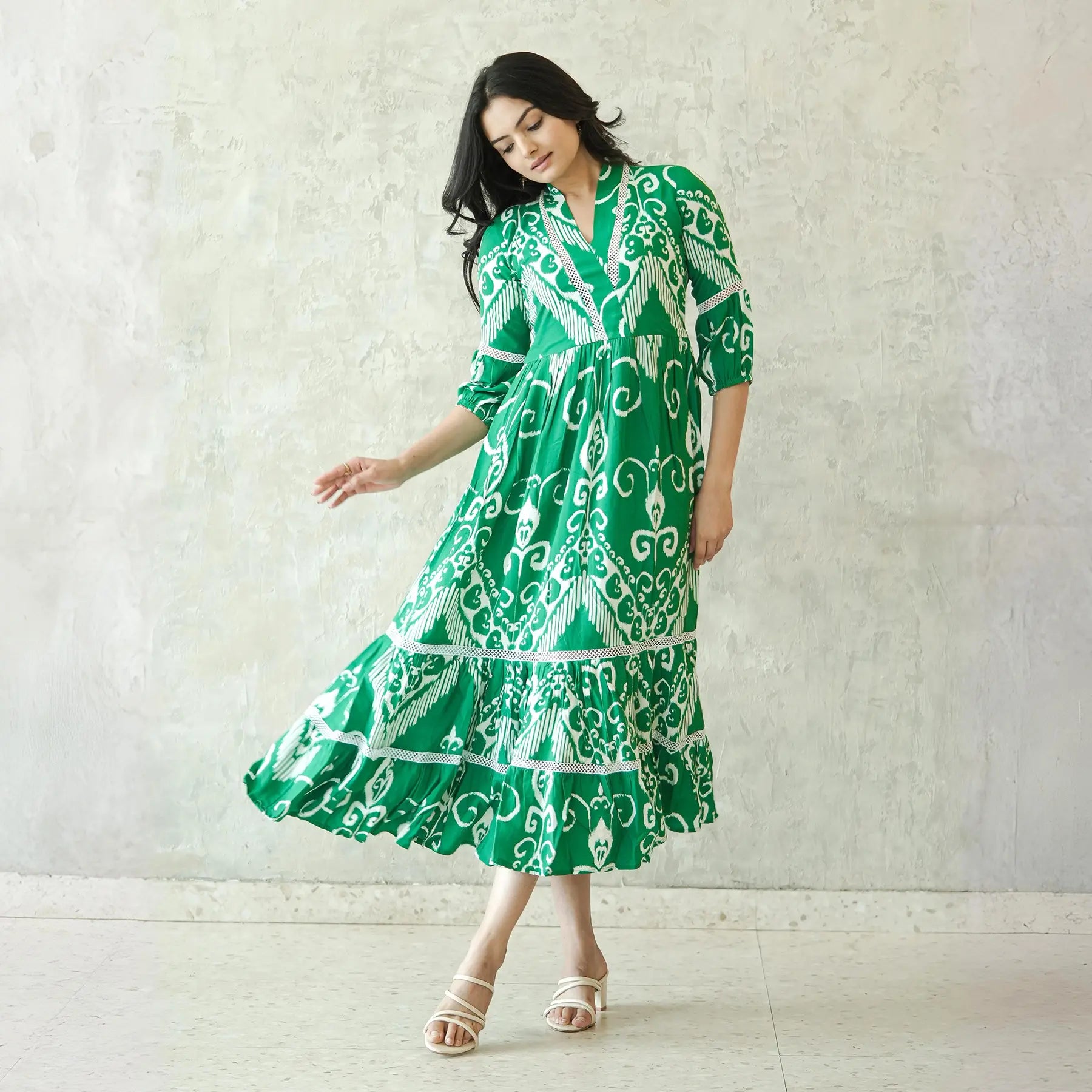 Model twirling in a green ikkat print a line midi dress for women, perfect as a summer midi dress.
