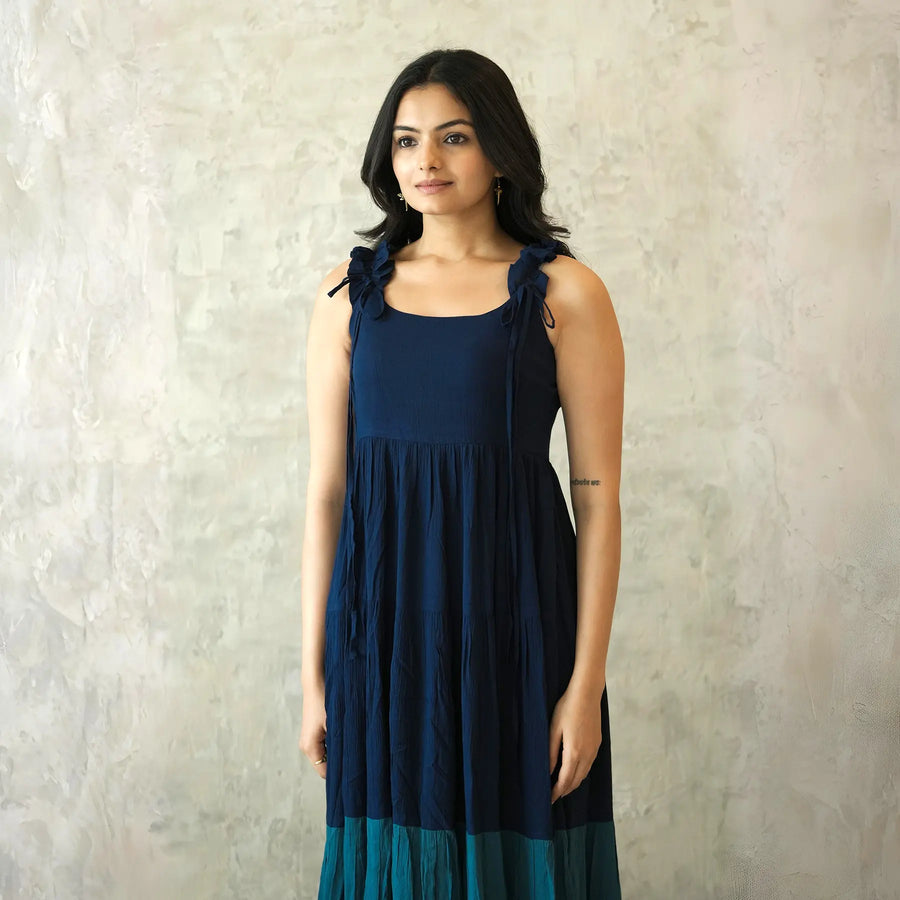Close-up showing square neckline and shoulder tie detail of a sleeveless midi dress.