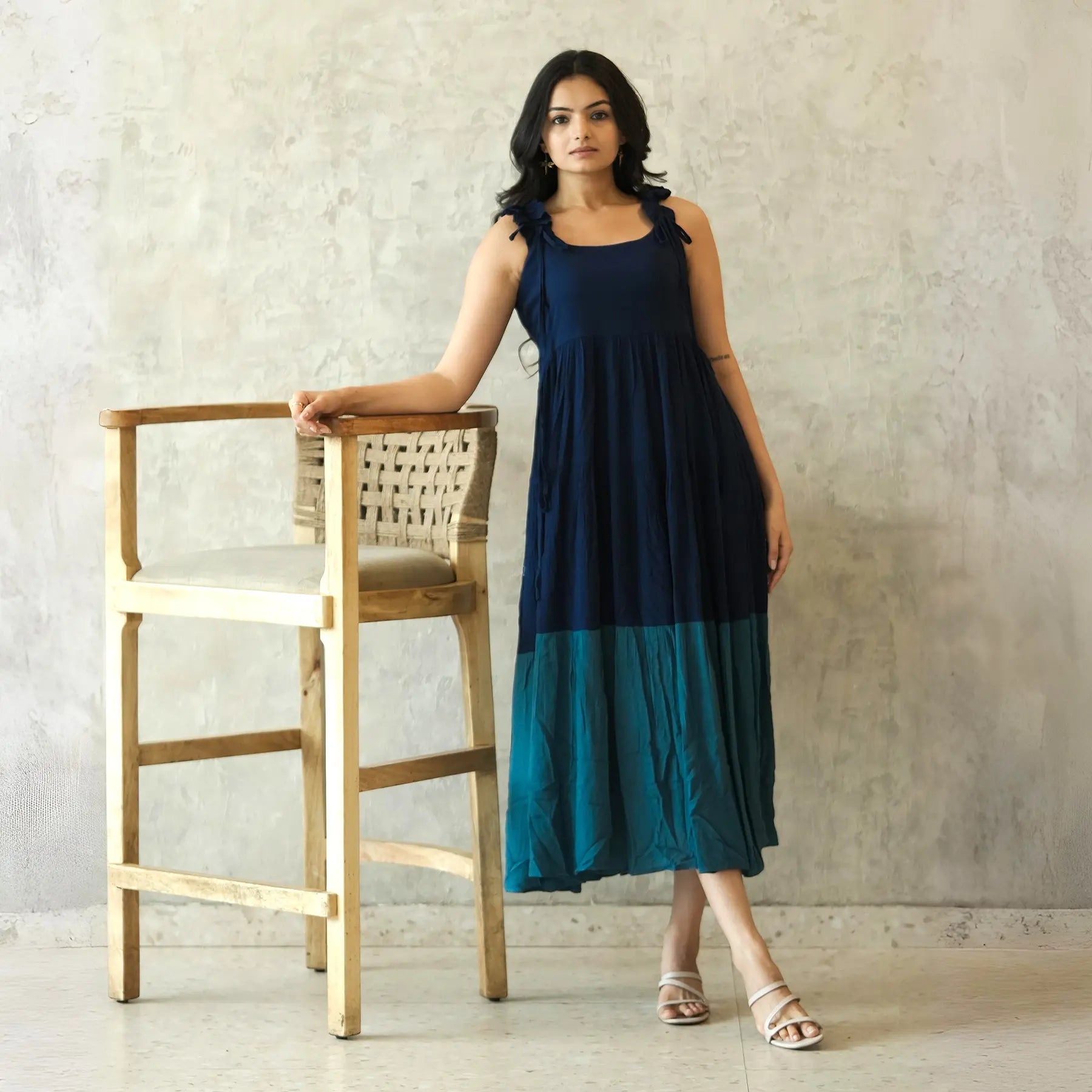 Sleeveless A-line midi dress with a breezy flow, styled casually for brunch or summer outings.