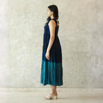 Side view of sleeveless midi dress with airy silhouette, an elegant choice for beach wear.