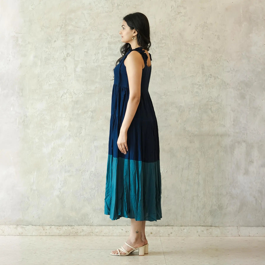 Side view of sleeveless midi dress with airy silhouette, an elegant choice for beach wear.