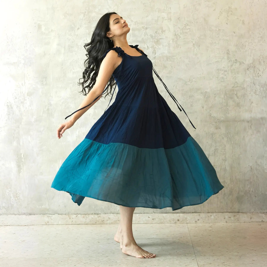 Sleeveless one piece with tied shoulder straps, twirling playfully, ideal for summer birthdays.