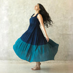 Flowy A-line midi dress captured mid-twirl — a chic outfit for resort wear.