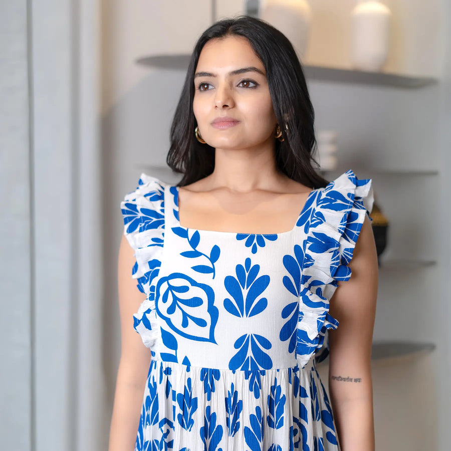 Close-up of blue and white leafy midi dress with frill detailing, highlighting neckline and shoulder design.