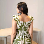 Back view of green leaf print A-line midi dress with sleeveless straps, perfect as a summer beach dress.