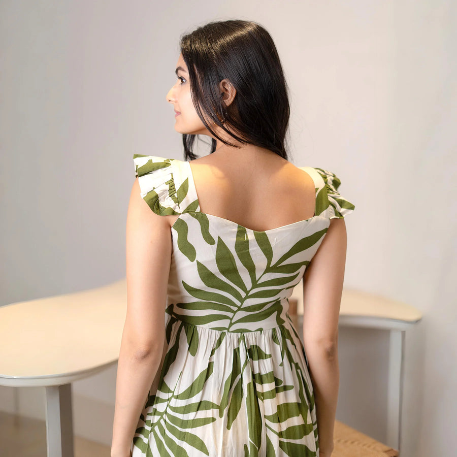 Back view of green leaf print A-line midi dress with sleeveless straps, perfect as a summer beach dress.