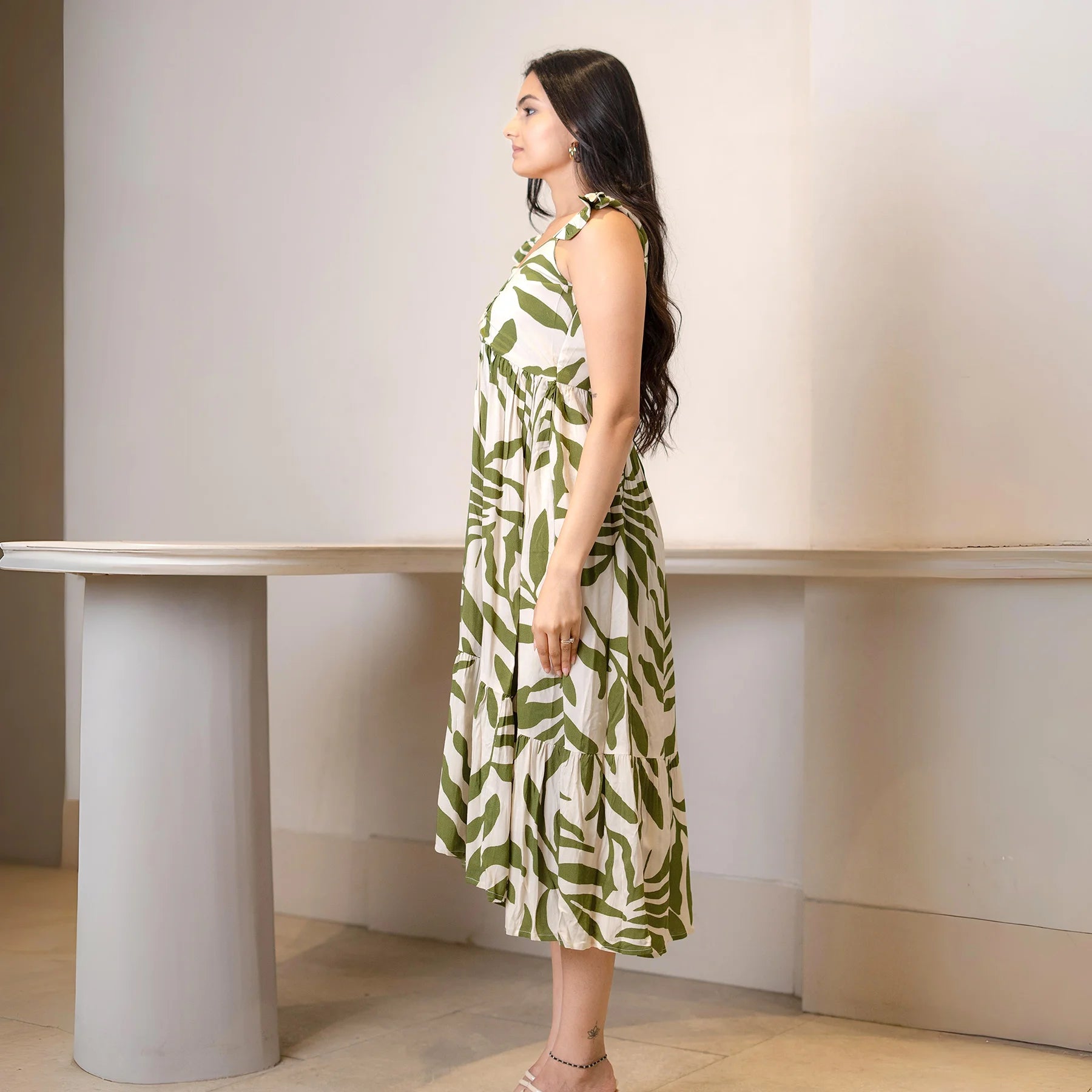 Side view of a sleeveless midi dress with leafy print, showing its flowy A-line cut ideal for beach wear and vacations
