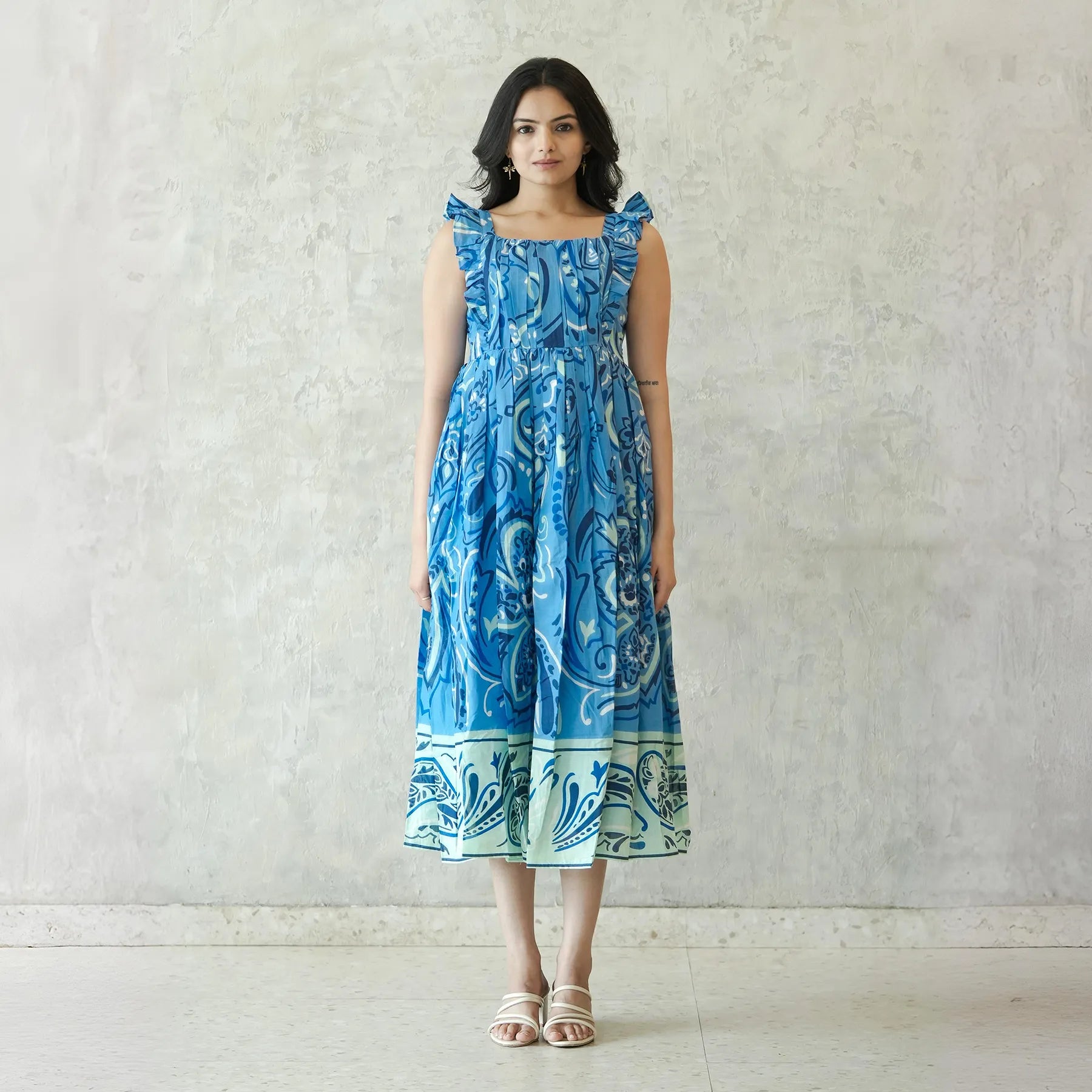 Model wearing blue printed A-line midi dress for women — sleeveless and flowy, ideal as a summer midi dress.