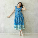 Model leaning in lightweight summer midi dress perfect for brunch or vacations.