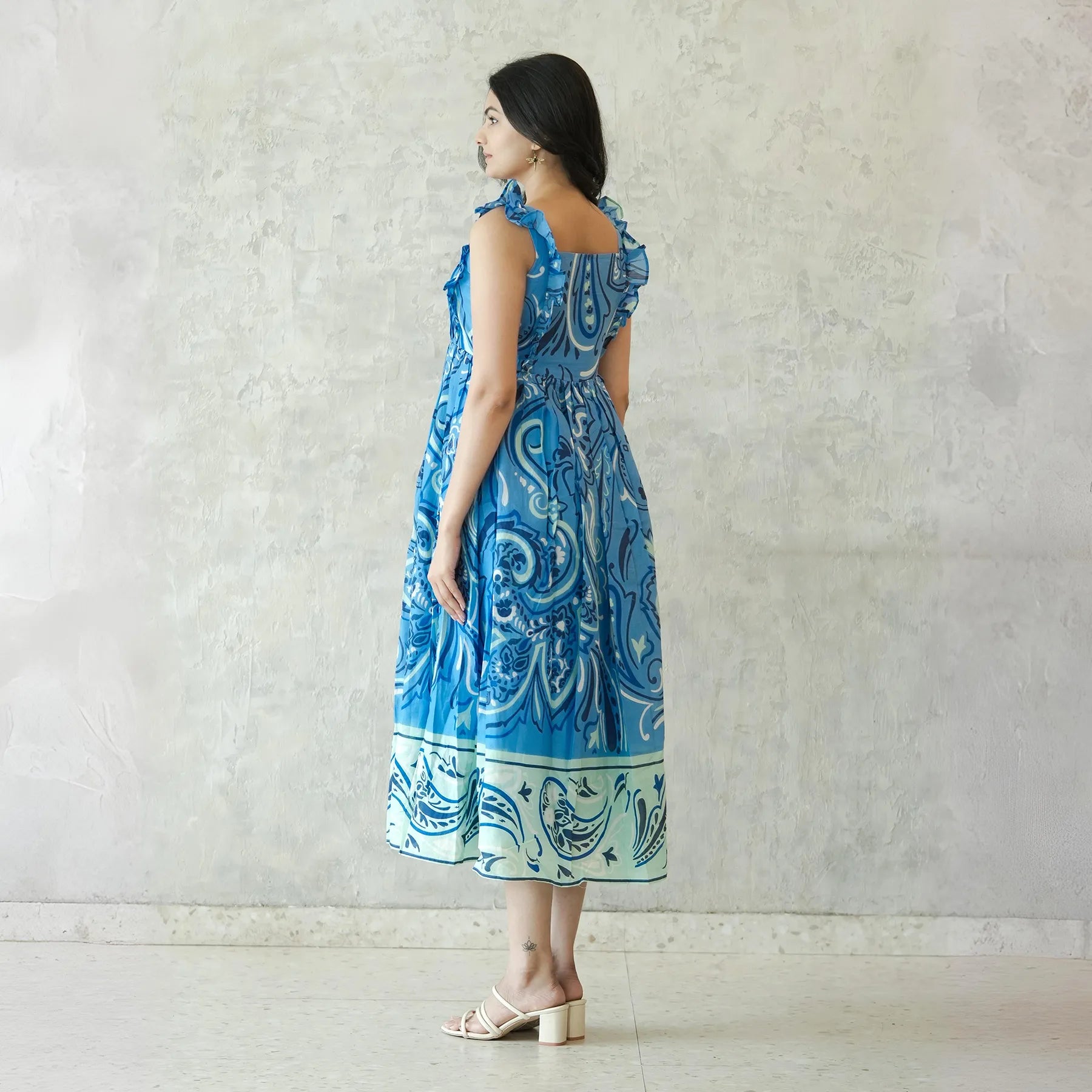 Side view of sleeveless midi dress with ornamental blue patterns — perfect for beach and casual outings.
