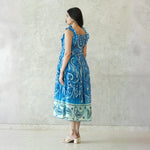 Side view of sleeveless midi dress with ornamental blue patterns — perfect for beach and casual outings.