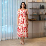 Model in a red leaf print midi dress with cold-shoulder sleeves, styled for brunch or summer outings.