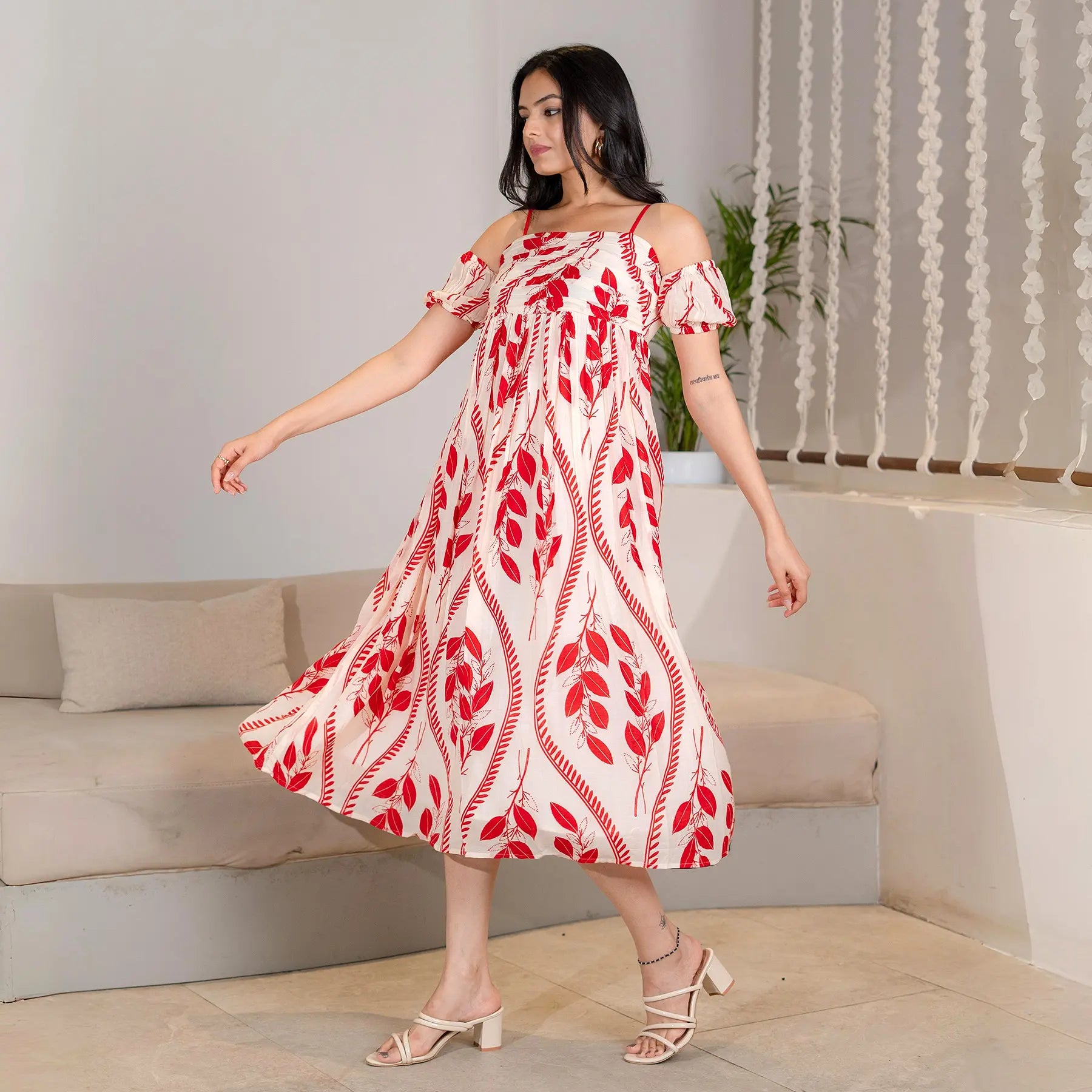Side view of a breezy A-line midi dress with bold red leaf patterns, perfect for casual celebrations.