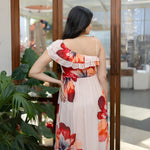 Back view of a sleeveless floral one piece dress, showcasing a ruffled one-shoulder detail.