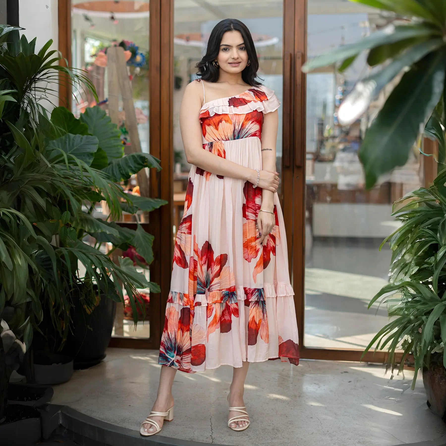 Woman in a sleeveless floral midi dress with bold red petal prints, ideal as a summer midi dress for women.