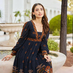 Woman in a black dress – sitting pose showcasing viscose fabric and puff sleeves, perfect for brunch look.